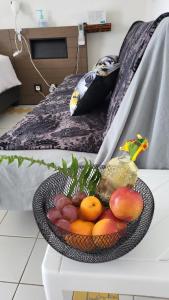 a bowl of fruit on a table next to a bed at LE PLAISIR DU Manganao in Saint-François