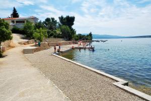 ヤセニクセにあるApartments with parking space Maslenica, Novigrad - 12636の水の桟橋に立つ群衆