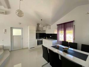 ヤセニクセにあるApartments with parking space Maslenica, Novigrad - 12636のテーブルと椅子のあるキッチンとダイニングルーム