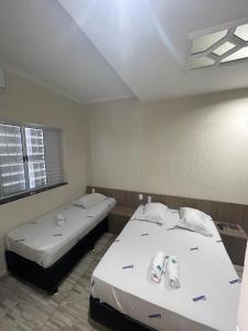 um quarto com duas camas e uma janela em Hotel Aricanduva em São Paulo