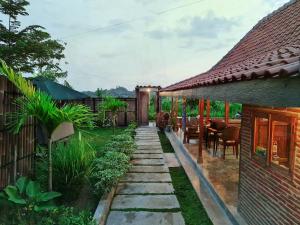 a garden with a stone walkway next to a house at Villa Kayu Yogyakarta in Yogyakarta