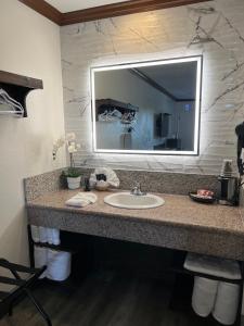 baño con lavabo y espejo grande en Starlight Inn Huntington Beach, en Huntington Beach