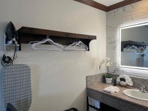 a bathroom with a sink and a mirror at Starlight Inn Huntington Beach in Huntington Beach