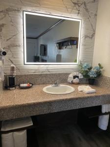 W łazience znajduje się umywalka i lustro. w obiekcie Starlight Inn Huntington Beach w mieście Huntington Beach