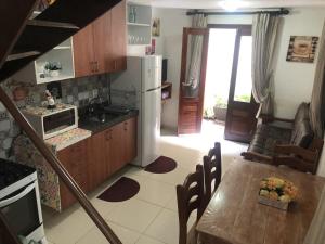 a kitchen with a table and a white refrigerator at TRIPLEX SOLAR CASA BRANCA in Guaramiranga