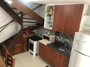 a small kitchen with wooden cabinets and a staircase at TRIPLEX SOLAR CASA BRANCA in Guaramiranga