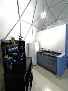 uma cozinha com um balcão preto e um frigorífico em Domo geodésico_conforto e relaxamento na natureza em Socorro