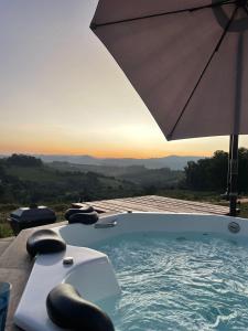 bañera de hidromasaje con sombrilla en la cubierta en Domo geodésico_conforto e relaxamento na natureza en Socorro