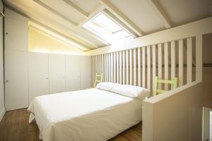 a bedroom with a white bed and a skylight at Luxury Studio with amazing Terrace in Porto