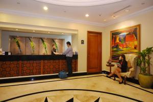 two people standing at a bar in a hotel lobby at Oxford Suites Makati in Manila