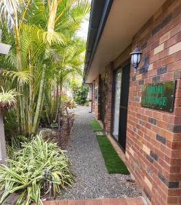 ein Backsteingebäude mit einem Schild, das neues Dorf liest in der Unterkunft Brom Cottage in Mooloolah