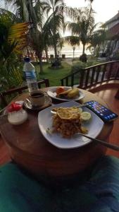 una mesa con dos platos de comida y una botella de agua en The Umah Prahu en Nusa Penida