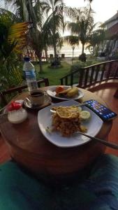 a table with two plates of food and a bottle of water at The Umah Prahu in Nusa Penida +50 photos
