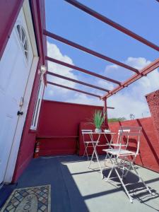 a patio with two chairs and a red house at Newly remodeled 1 bed, 1 bath home near LAX, Forum in Inglewood