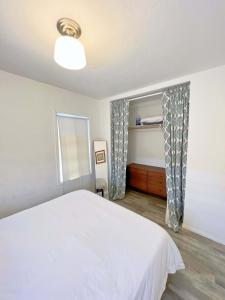 a bedroom with a white bed and a window at Newly remodeled 1 bed, 1 bath home near LAX, Forum in Inglewood
