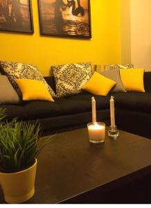 a living room with a black couch with two candles on a table at Golf Porto marina in El Alamein