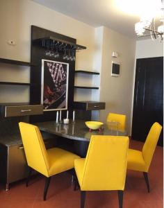 a dining room with a table and yellow chairs at Golf Porto marina in El Alamein