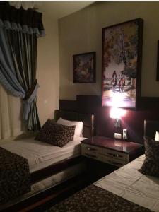ein Hotelzimmer mit 2 Betten und einem Tisch mit einer Lampe in der Unterkunft Golf Porto marina in El-Alamein