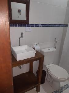 uma casa de banho com um WC branco e um lavatório. em Pousada Recanto Afetivo em Trindade