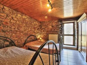 Habitación con 2 camas y pared de piedra. en Rustic holiday home in Sainte-Ode with garden, en Sainte-Ode
