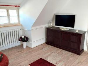 GladauAttic Holiday Home with Garden and Grill的客厅配有梳妆台上的平面电视