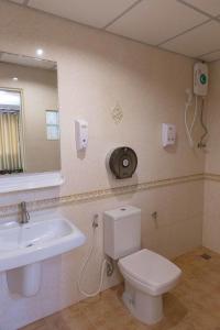 ein Badezimmer mit einem WC, einem Waschbecken und einem Spiegel in der Unterkunft Honey House 3 in Jomtien Beach