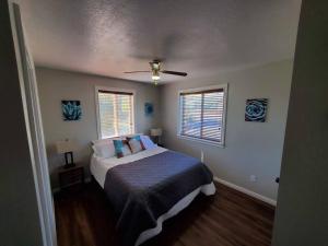 Schlafzimmer mit einem Bett und einem Deckenventilator in der Unterkunft Bear Lake Emerald Retreat with lake view. in Garden City