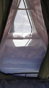a small bed in a tent with a window at Terras de Maria Bonita in Paraty