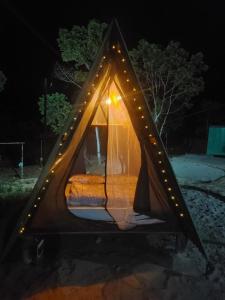 a bed in a tent with lights around it at Terras de Maria Bonita in Paraty