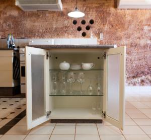 a cupboard with glasses in it in a kitchen at Ali's Underground Home in Coober Pedy