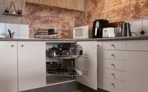 a kitchen with white cabinets and a microwave at Ali's Underground Home in Coober Pedy