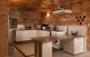 a kitchen with white cabinets and a counter top at Ali's Underground Home in Coober Pedy