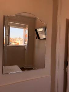 Angels Homes-n27, 3ºfloor - Bairro Típico, Centro Lisboa في لشبونة: مرآة على جدار الحمام مع نافذة