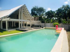 a swimming pool in front of a house at passifika house in Canggu