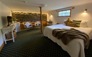 Hanlon Guest House في ستانلي: غرفة فندقية بسرير كبير واريكة