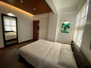 een slaapkamer met een wit bed en een spiegel bij Luxury 3 Room Apartment by Oboe in Male City