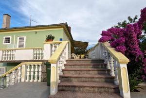 a staircase leading to a house with purple flowers at Apartment Mili - 50m from beach in Sutomišćica