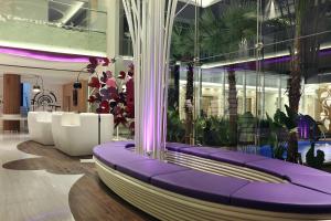 a lobby with purple benches and plants in a building at Mercure Jakarta Sabang in Jakarta