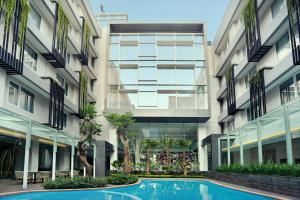 an external view of a building with a swimming pool at Mercure Jakarta Sabang in Jakarta