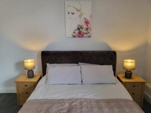 a bedroom with a bed with two lamps on tables at 1 Lytham Terrace in Carnforth