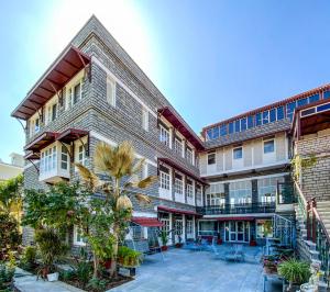 an apartment building with a courtyard with palm trees at Sajjan Niwas in Udaipur