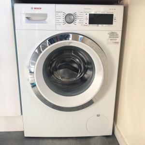 a white washing machine sitting in a room at 2 Bedroom, Near Station, Fast WI-FI, Free Parking! in London