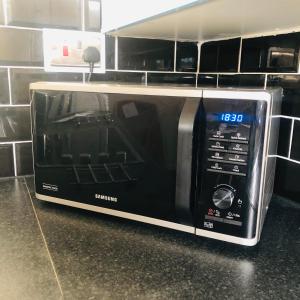 a microwave oven sitting on a counter in a kitchen at 2 Bedroom, Near Station, Fast WI-FI, Free Parking! in London