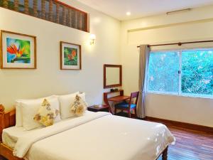 a bedroom with a large white bed and a window at My Key Polanka Pirvate Villa with Pool in Siem Reap
