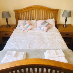 Una cama con 2 mesitas de noche con toallas. en 2 Bedroom, Near Station, Fast WI-FI, Free Parking!, en Londres