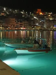 um barco sentado na água à noite em Cosy Studio em Sitia