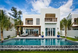 une villa avec une piscine en face d'une maison dans l'établissement Stelia Beach Resort, à Tuy Hoa