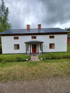 una gran casa blanca con puerta roja en Kopparhyttan1 en Valdemarsvik