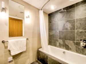 een badkamer met een douche en een bad bij Haven House in Lochgilphead