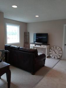 a living room with a black couch and a television at Why Pay Outer Banks (OBX) Beach Prices? Sleeps 9+ in Columbia